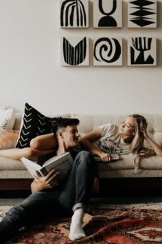 a man and woman are laying on a couch