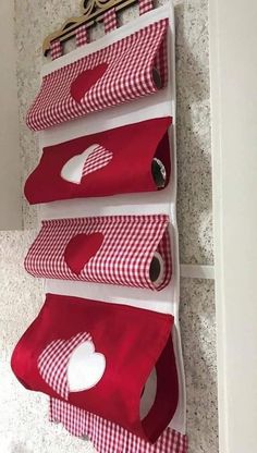 three red and white storage bins hanging on the side of a wall in a bathroom