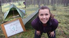 a woman kneeling down in the woods next to a tent with a drawing on it