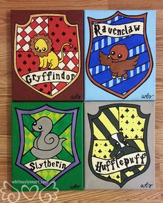 four harry potter crest magnets on a wooden table with the words ravenclaw, gryffindor, slytherin and hogwart