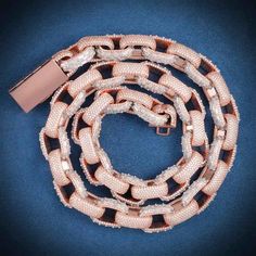 a pink and white chain with two clasps on it, sitting on a blue surface