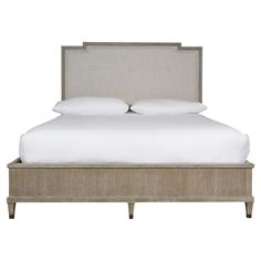 an upholstered bed with white linens and beige headboard, made in the usa