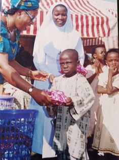 a woman handing something to a small child