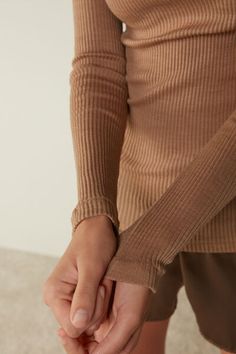 Long-sleeve high-neck tubular top made from a wool-silk blend. Beige Turtleneck Top With Ribbed Cuffs, Beige Stretch Top With Ribbed Cuffs, Elegant Winter Tops With Thumbholes, Elegant Loungewear Tops For Winter, Elegant Winter Tops For Loungewear, Elegant Winter Loungewear Tops, Beige Seamless Collar Top For Fall, Lingerie Accessories, Lingerie Collection