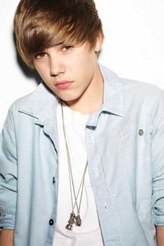 a young man wearing a blue shirt and necklace