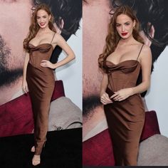 a woman in a brown dress posing for pictures on the red carpet at an event