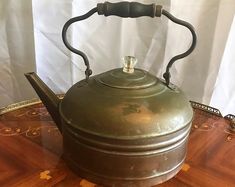 a tea kettle sitting on top of a wooden table