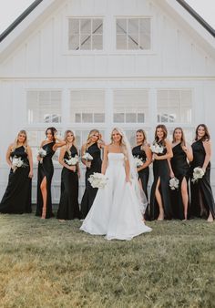 a group of women standing next to each other in front of a white building