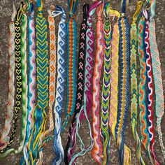 several different colored bracelets are laid out on the ground together, with one being tied up