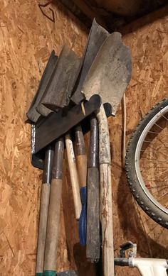 there are many different tools in the storage area on the wall next to the bike