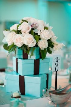 a blue box with white flowers in it on top of a table next to other items