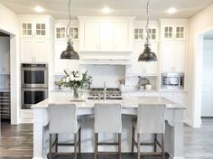 a large kitchen with white cabinets and an island