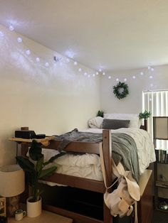 a bed room with a neatly made bed next to a night stand and some plants