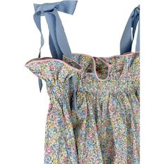 the back of a dress with blue ties hanging from it's shoulder and floral print