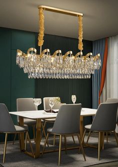 a chandelier hanging over a dining table in a room with green walls and curtains