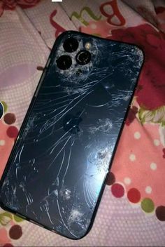 a broken cell phone sitting on top of a bed