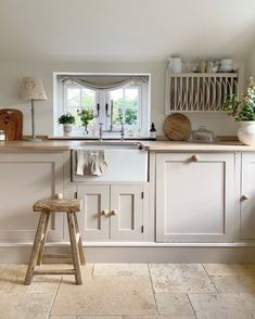 a kitchen with white cabinets and wooden stools