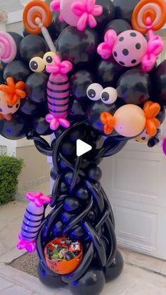 a bunch of balloons that are in the shape of a tree with faces on them