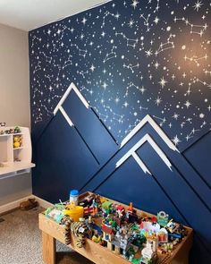 a child's room with mountains painted on the wall and stars in the sky