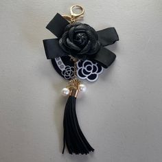 a key chain with a flower and tassel hanging from it's side on a wall