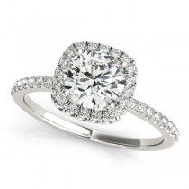 a white gold engagement ring with diamonds on the band and an oval halo setting in the center