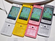 five cell phones are lined up on a table