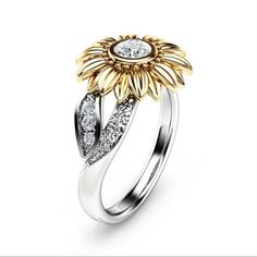 a gold and silver flower ring with diamonds on the bottom, surrounded by two rows of white