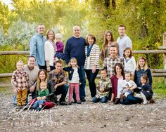 a large group of people standing next to each other in front of a wooden fence