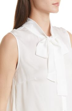 A tie detail at the neckline provides a refined finish for this woven sleeveless blouse. Ties at neck Sleeveless 100% polyester Hand wash, line dry Imported Elegant Bow Tank Top For Spring, Workwear Sleeveless Silk Blouse, Chic Tops With Tie Back And Tie Neck, Elegant Sleeveless Tops For Office, Elegant White Blouse With Tie Back, Spring Workwear Blouse With Tie Back, Chic Tie Back Top For Work, Formal Summer Top With Tie Back, Chic Tie Back Blouse For Work