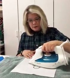 a woman ironing fabric with an electric iron