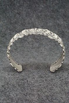 This stunning and intricate sterling silver bracelet was made by Navajo silversmith Eugene Charley. The inside is signed and stamped sterling.Size: 6" (will fit up to a 7 3/8" wrist)Gap: 1 3/8"Width: 1 1/2"Free shipping on all orders! We ship with USPS and always include tracking. All orders ship within a day of payment.Returns are accepted up to 30 days after you receive your order. Just send us a message. Our shop offers cash back or store credit. The item must be returned in new condition. Ornate Antique Silver Carved Jewelry, Adjustable Carved Sterling Silver Jewelry, Bohemian Carved Sterling Silver Jewelry, Antique Silver Adjustable Cuff Bracelet With Intricate Design, Adjustable Ornate Sterling Silver Bangle, Ornate Sterling Silver Bangle Jewelry, Adjustable Antique Silver Cuff Bracelet With Intricate Design, Ornate Antique Silver Sterling Bracelets, Sterling Silver Cuff Bracelet With Intricate Design