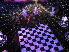 a checkered floor is lit up with christmas lights