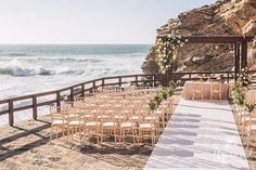 an outdoor wedding setup on the beach with chairs set up for it's ceremony