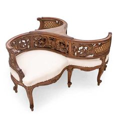 an ornate wooden bench with white cushions