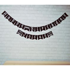 a happy birthday banner hanging on a brick wall