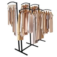 an assortment of clothes hanging on black racks