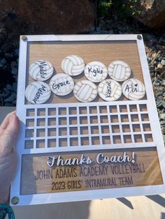 a person holding up a plaque with volleyballs on it that says thanks coach john adams academy volleyball