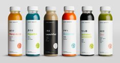 six different types of juices are lined up in a row on a gray background