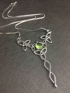 "I will fabricate this Celtic inspired pendant necklace, in sterling silver, featuring a center, faceted 8mm faceted Peridot! The frame, or centering, of the pendant is made with Celtic Trinity Knots and sterling wire work braids down the center to add the balancing touches to the piece. It comes with a sterling box chain which is soldered to each end of the pendant. This piece is 18\" in length, including the chain, and the pendant, itself, is approximately 2 1/2 inches in height and approximat Silver Faceted Sterling Silver Birthstone Necklace, Sterling Silver Necklace For May Birthstone Jewelry Making, Sterling Silver May Birthstone Necklace, Faceted Sterling Silver Birthstone Necklace For Jewelry Making, Sterling Silver Diamond Cut Jewelry For May Birthstone, Silver Faceted Peridot Jewelry, Silver Peridot Necklaces For Jewelry Making, Silver Pendant Necklace With Peridot, Silver Peridot Birthstone Jewelry