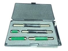 an assortment of green and black pens in a case on a white surface with the lid open