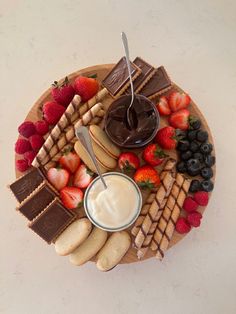 a platter filled with cookies, strawberries, crackers, and chocolate sauce