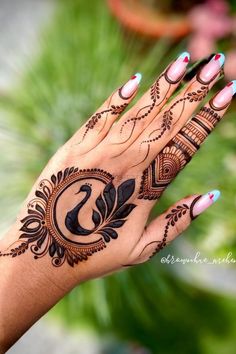 a woman's hand with henna tattoos on it