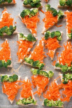 broccoli and carrots are arranged on top of crackers to be eaten