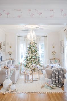 a living room filled with furniture and a christmas tree in the middle of the room