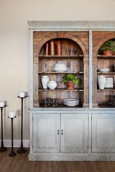 an old china cabinet with pots and pans on it