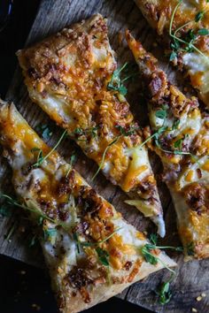 several slices of pizza sitting on top of a wooden cutting board