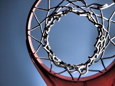 a basketball hoop with chains hanging from it's side and the sky in the background