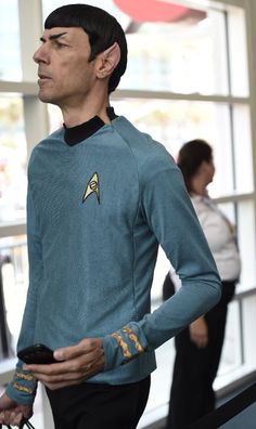 a man in a star trek uniform holding a cell phone