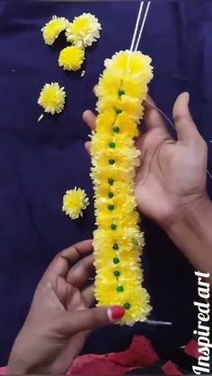 someone is making some yellow flowers out of yarn