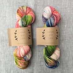 two skeins of yarn sitting next to each other on top of a table